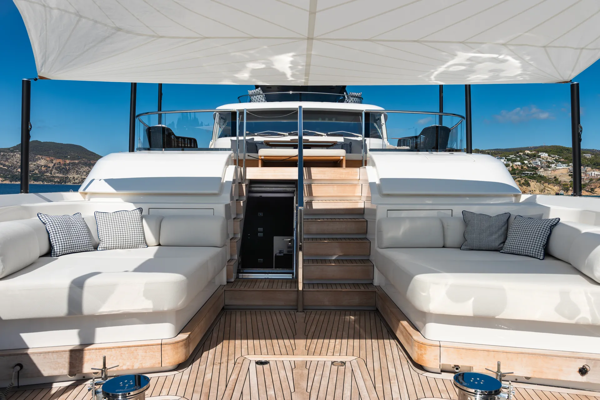 Bow lounge with two large sofas under a shade sail and steps in the centre