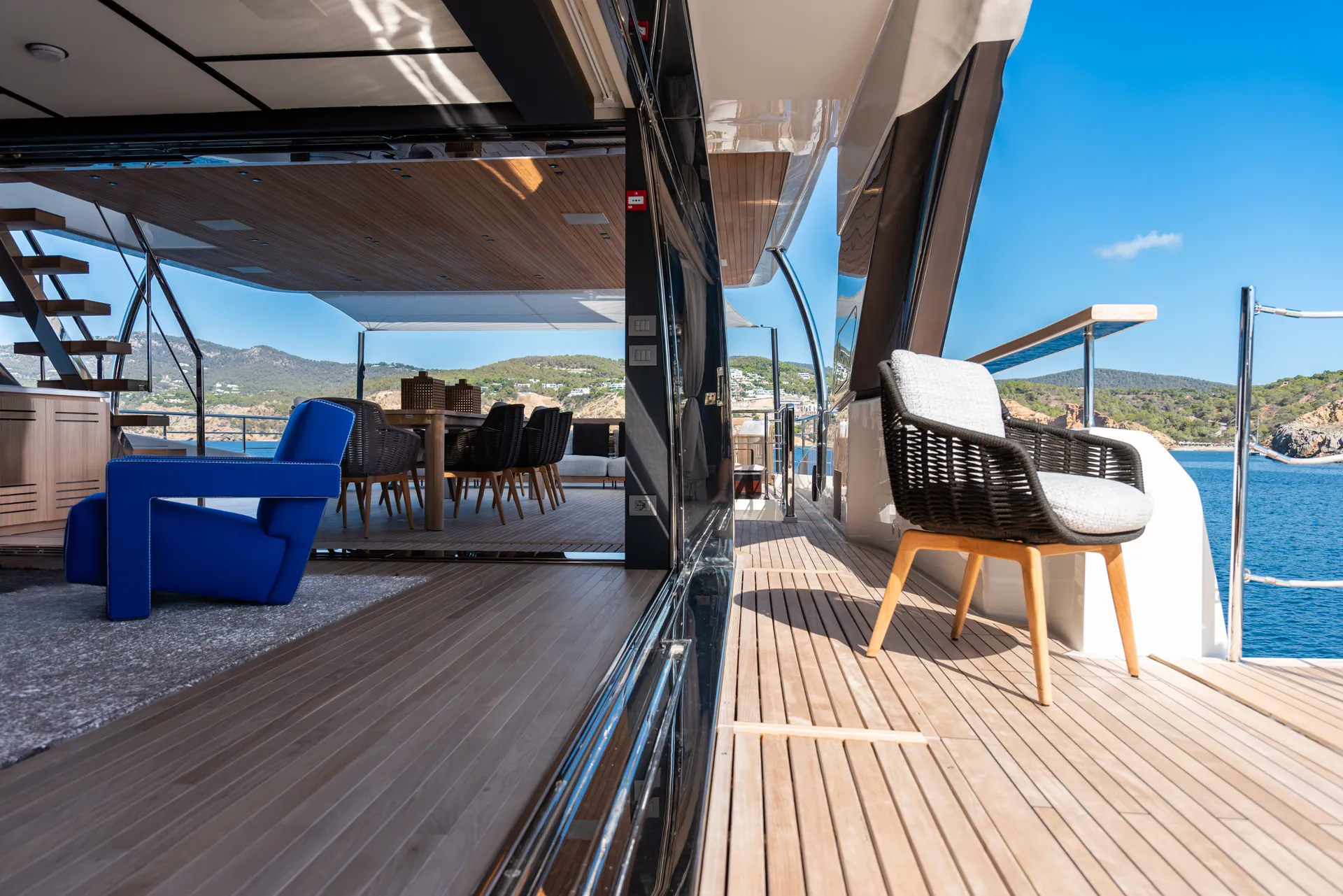 Chair on the portside balcony, the upper deck lounge with its blue armchairs behind the open glass