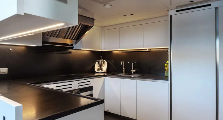 Galley with white cabinets and black counters